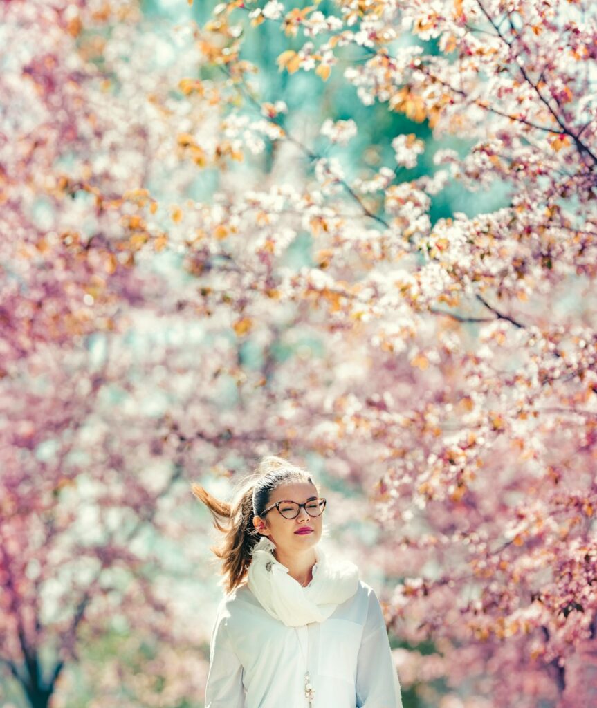 woman standing on pink cherry trees sorrounded area