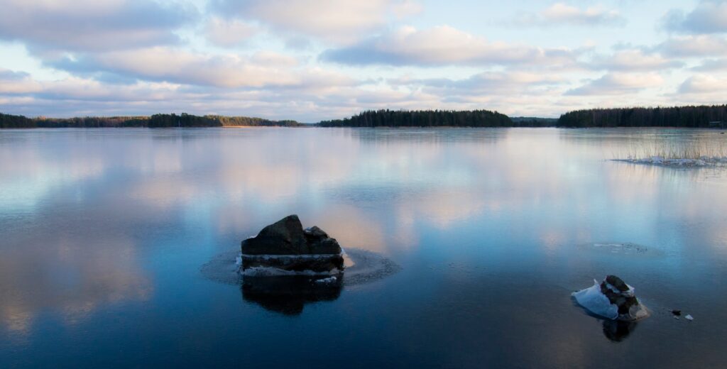 a large body of water with a rock in the middle of it